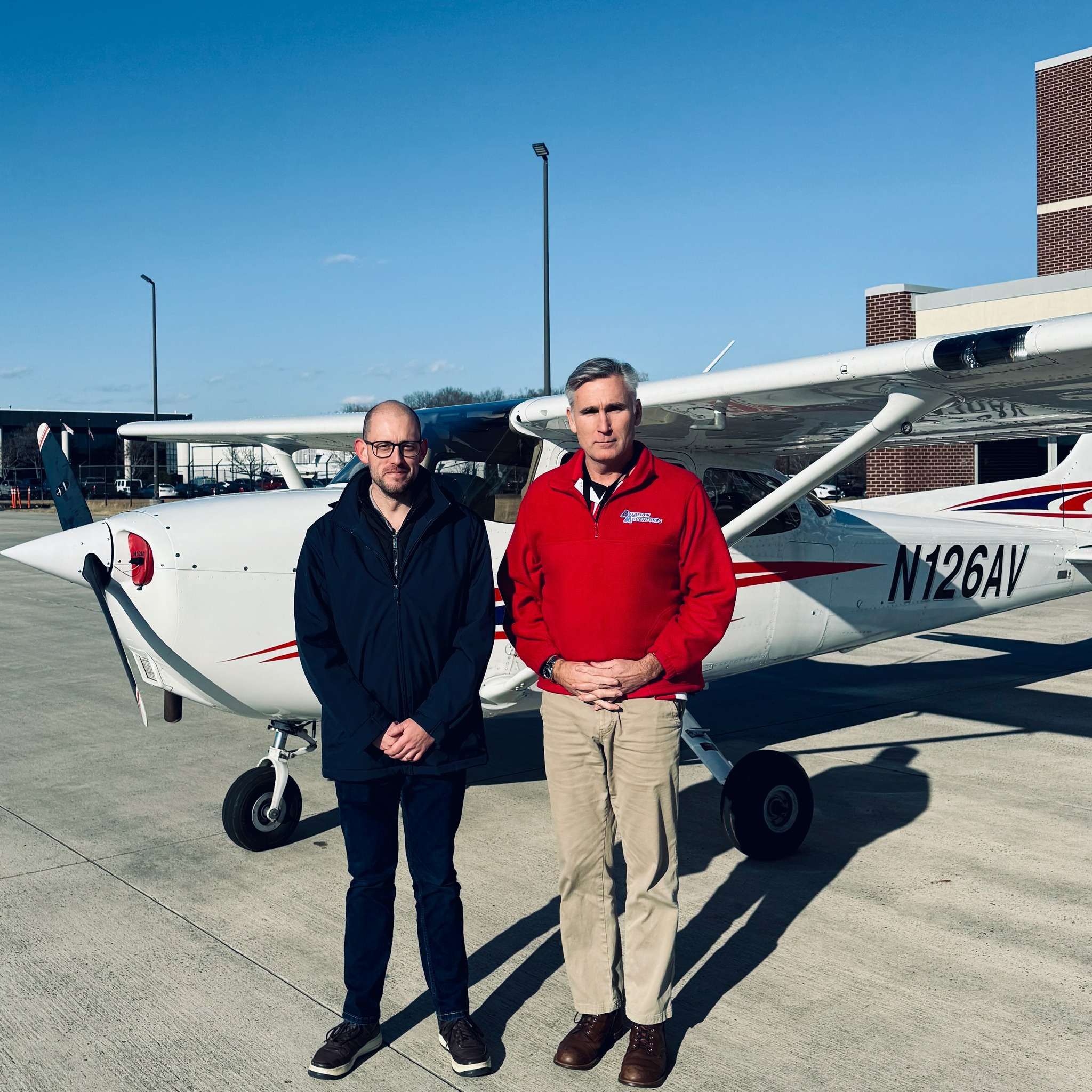 Instructor and student standing near the Cessna.