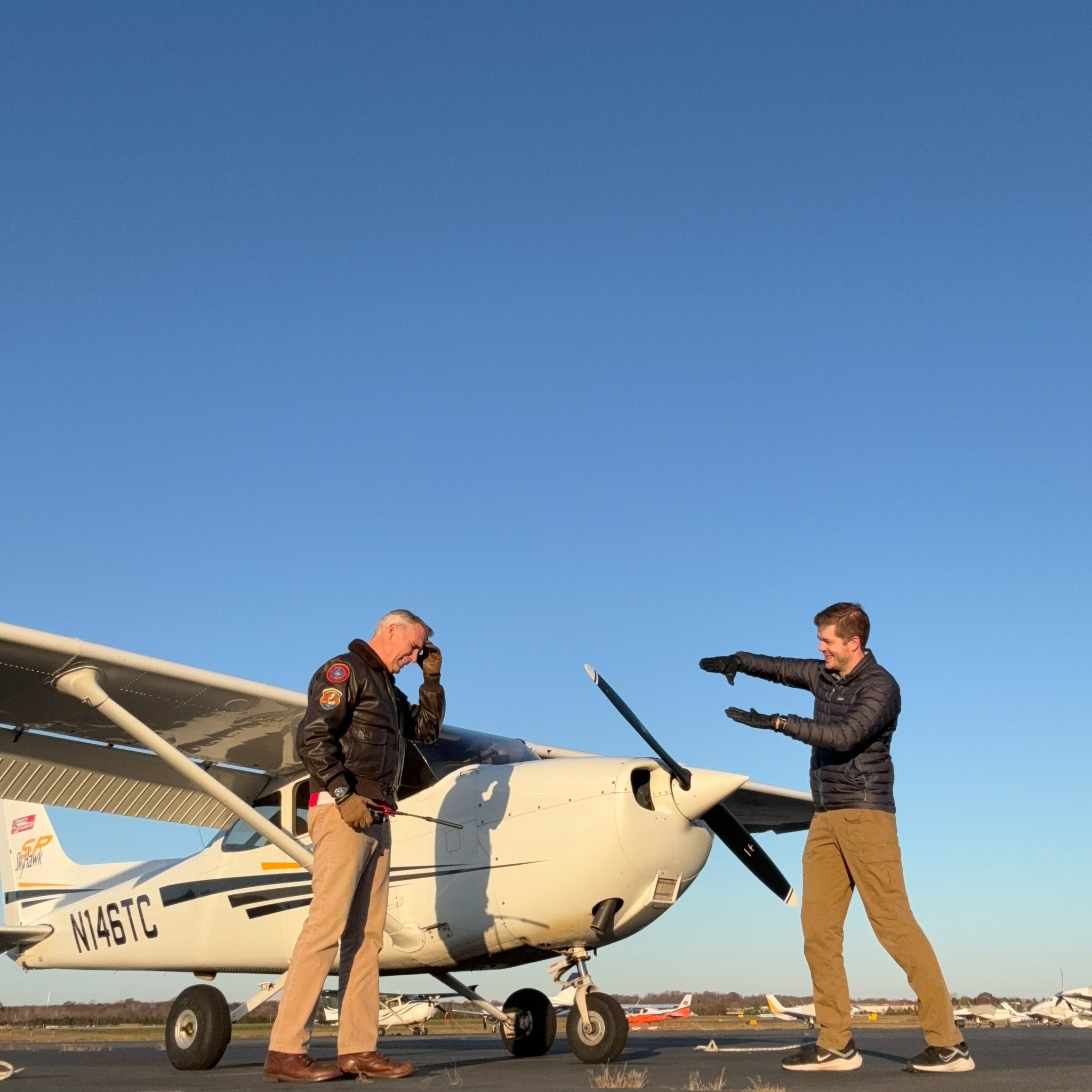 A student and instructor talking about flying, with their hands.